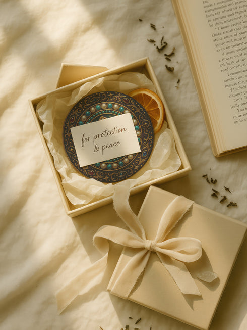 Round ceramic coaster with a central opal teardrop design surrounded by baroque-style celestial elements including pearls, stars, and ornate gold detailing. Deep green and jewel-toned accents frame the mystical illustration. The coaster includes a non-slip cork backing and measures about 4 inches in diameter. Ideal for both hot and cold drinks, it fits whimsigoth, celestial, and antique-inspired home decor themes.